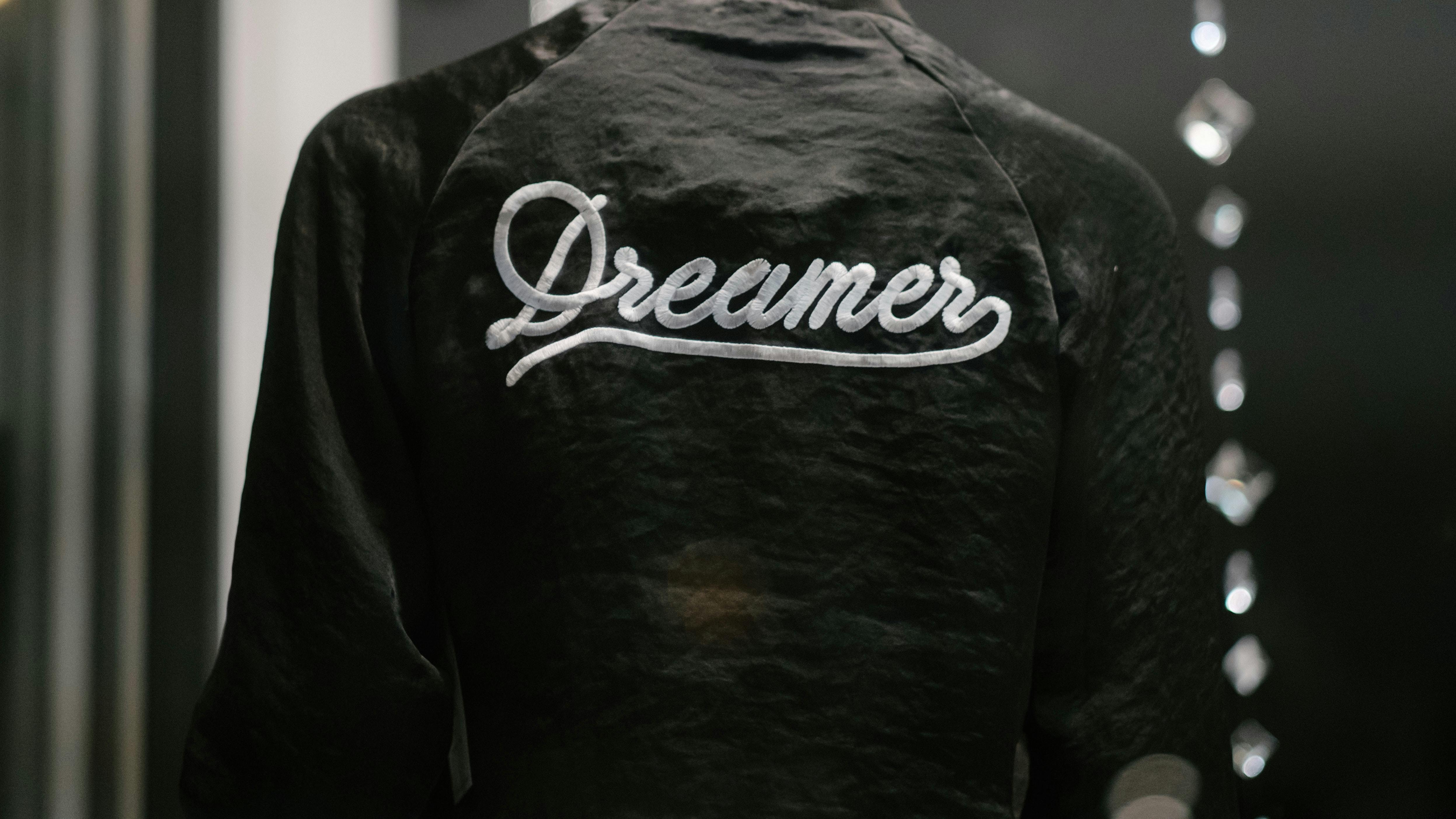 jacket with Dreamers written in cursive across the back - Photo by rob walsh on Unsplash