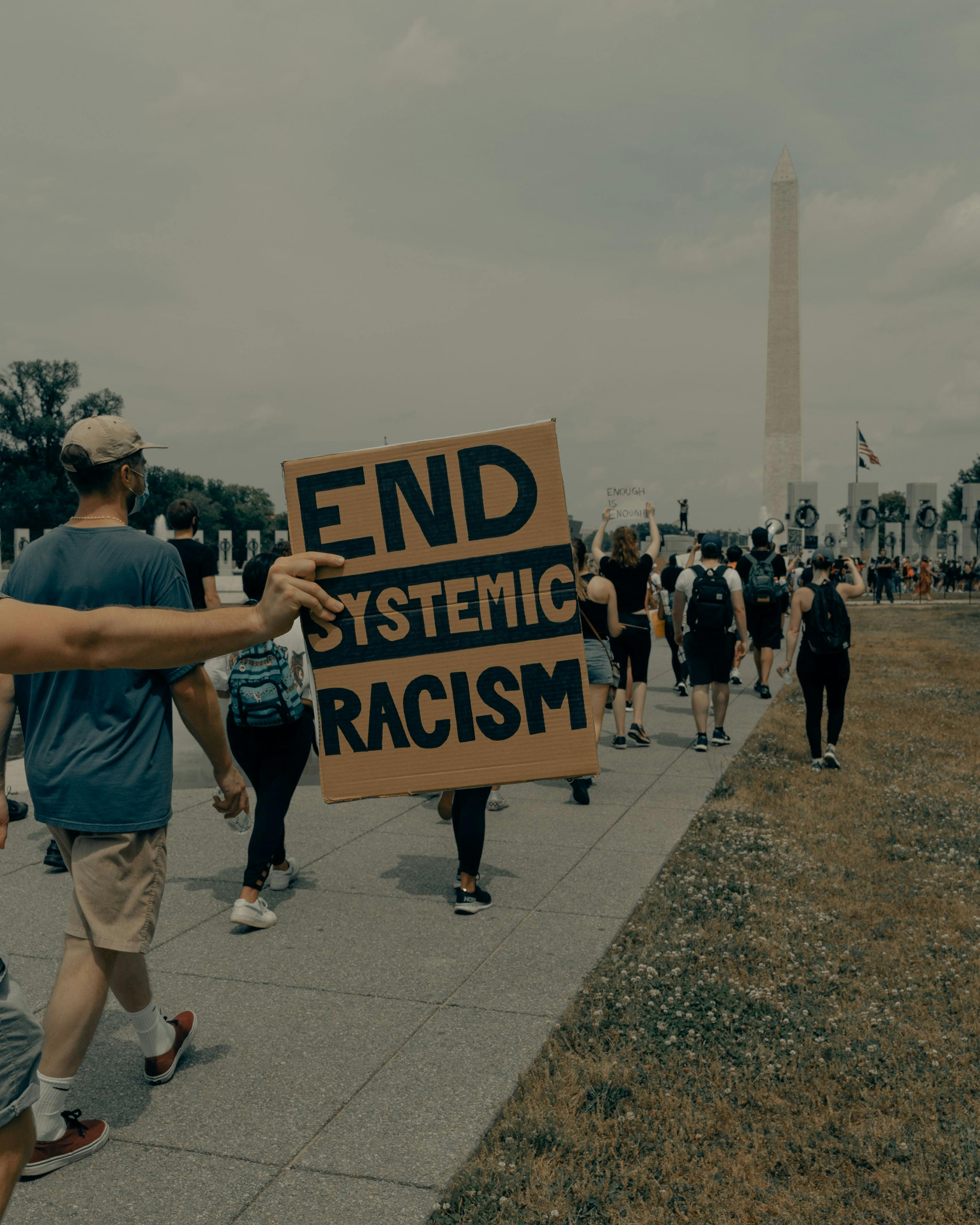 sign that says end system racism - Photo by Clay Banks on Unsplash