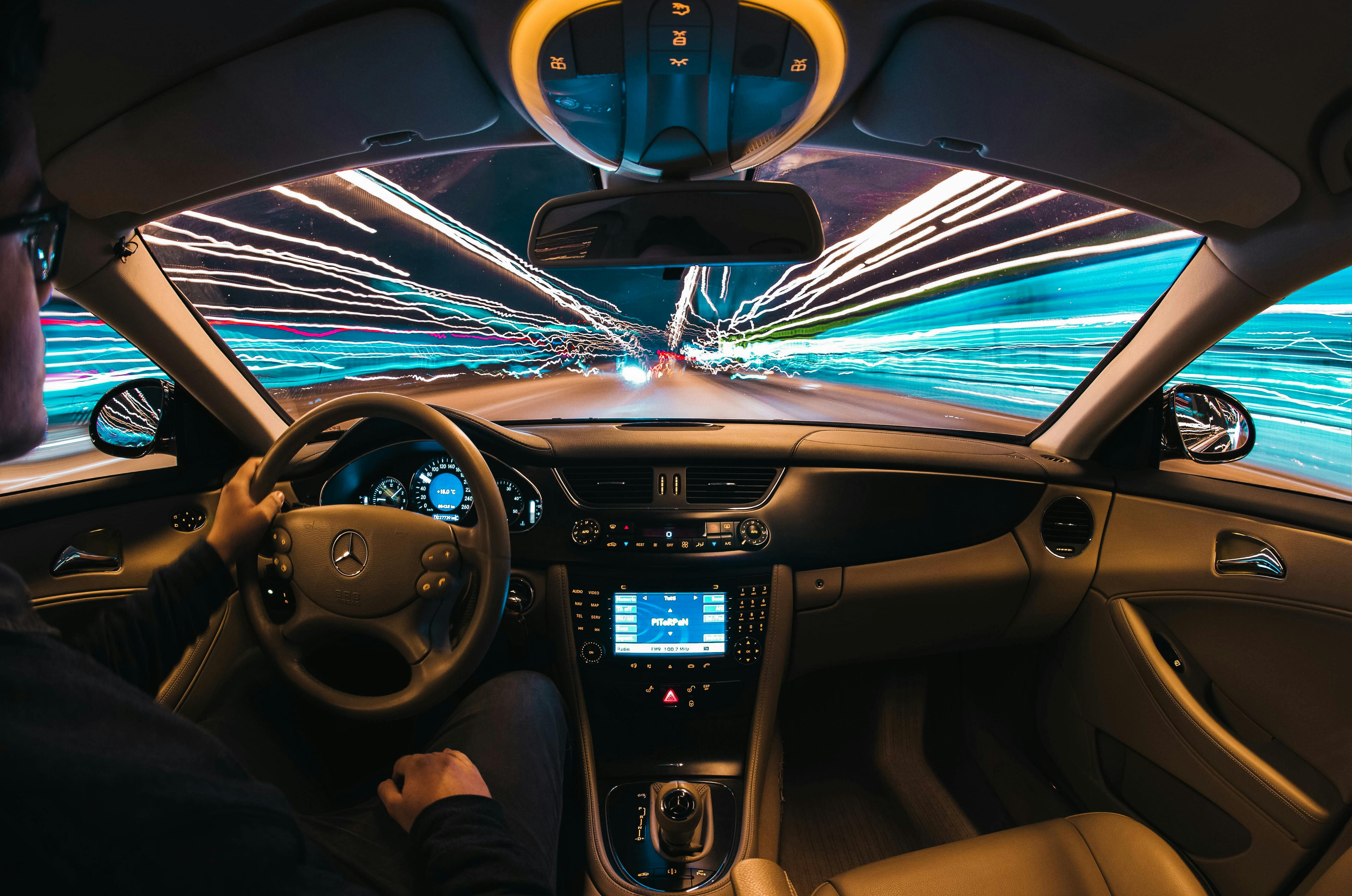 person driving car with many lights around - Photo by Samuele Errico Piccarini on Unsplash 