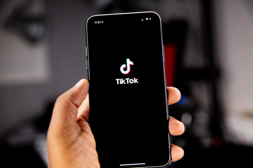 Person holding smartphone while launching the TikTok application. Photo by Solen Feyissa on Unsplash