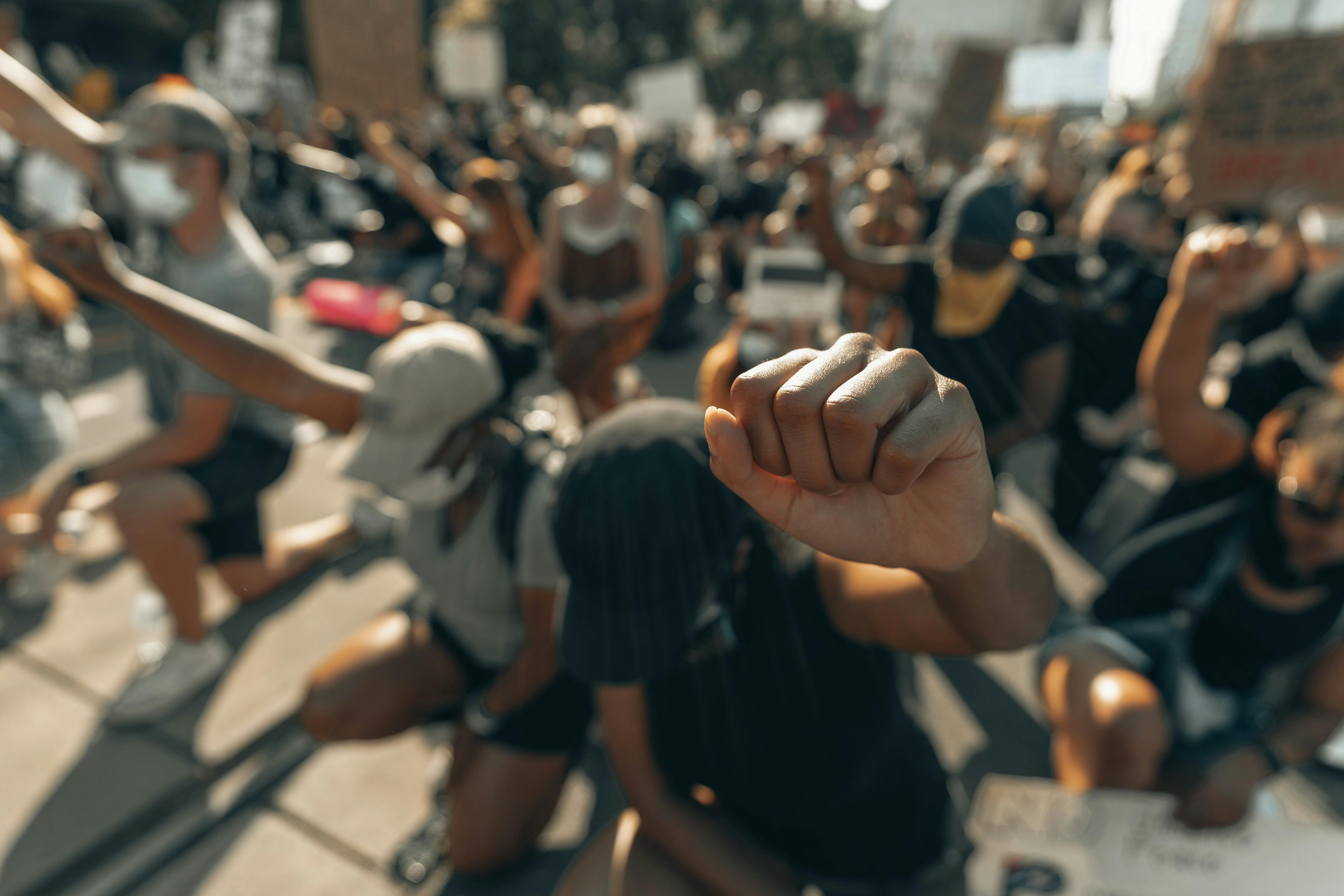 group of protestors with their fist up - Photo by Clay Banks on Unsplash