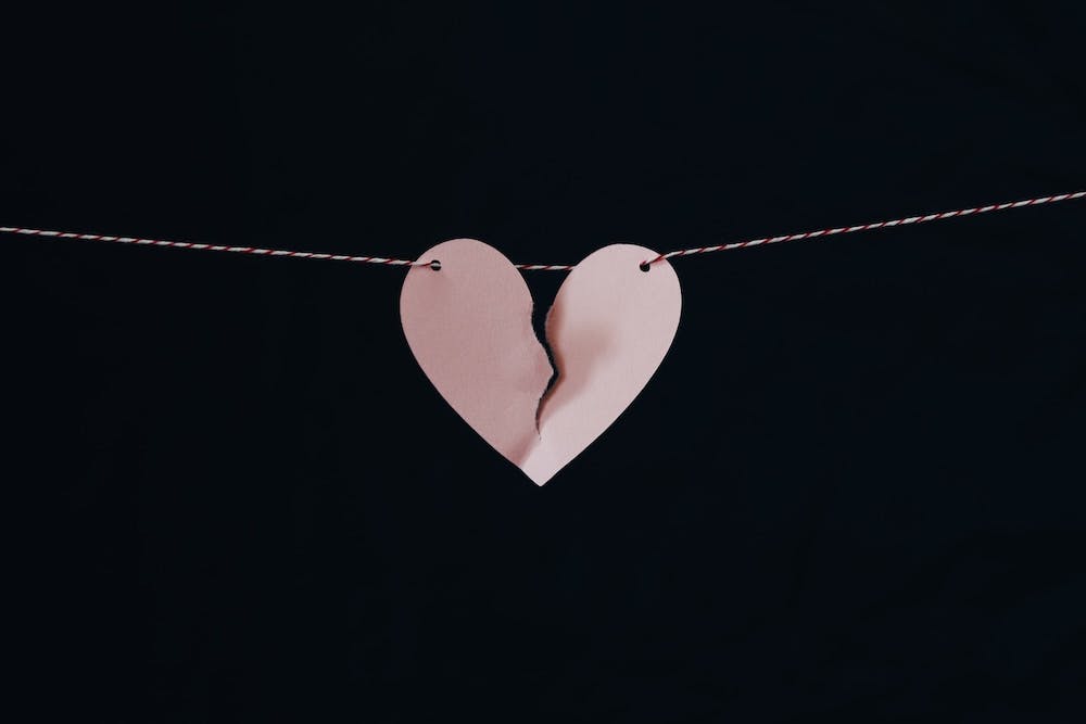 Paper heart hung on string ripped in half - Cover Photo by Kelly Sikkema on Unsplash