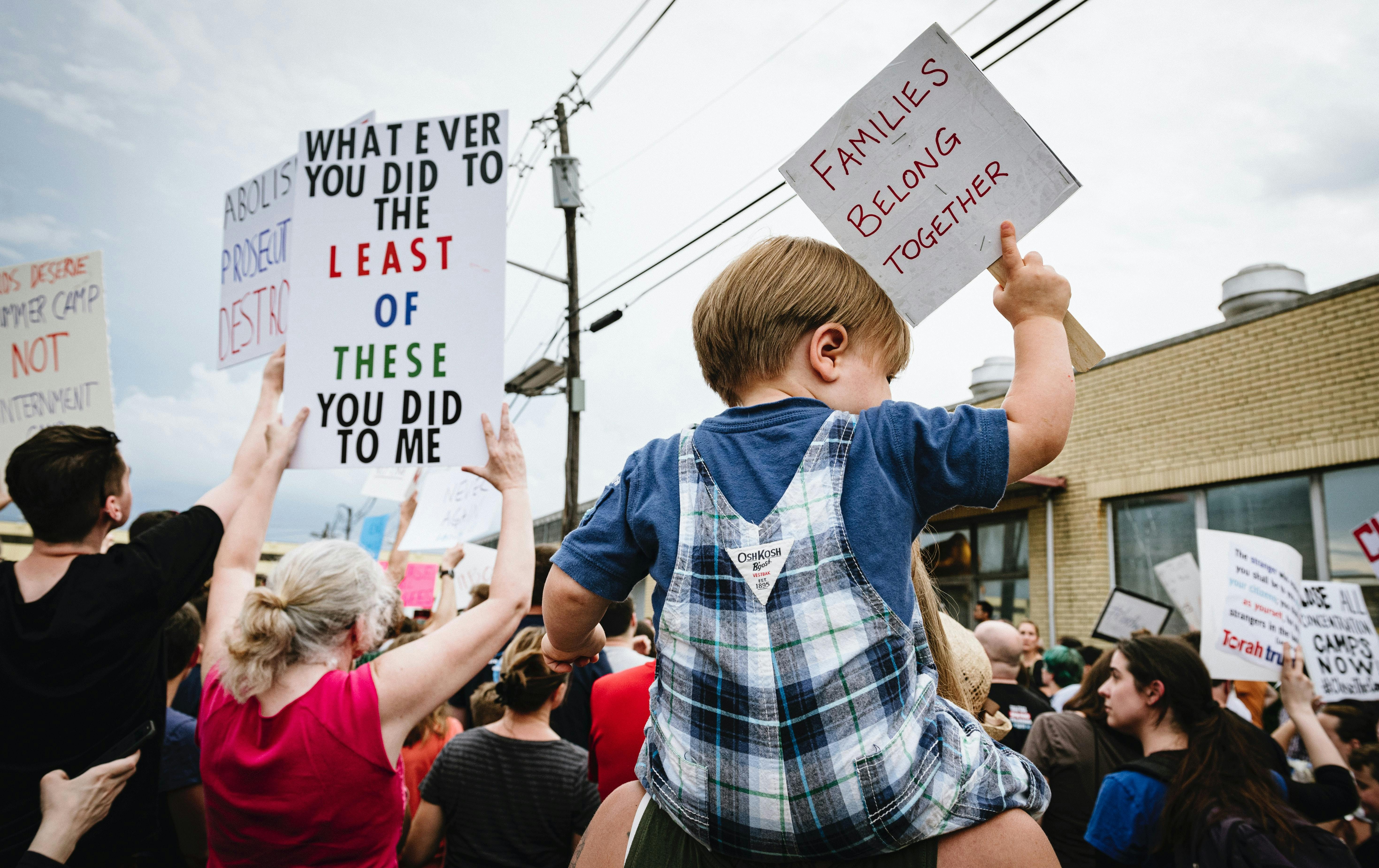 protest with sign - Families Belong Together. Photo by Chris Boese on Unsplash