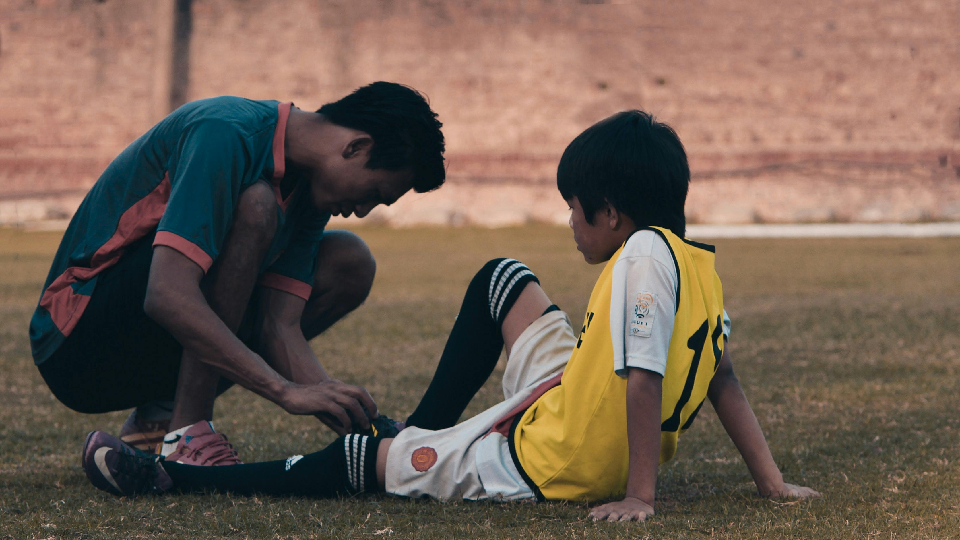 person helping soccer player injured - Photo by Yogendra Singh on Unsplash