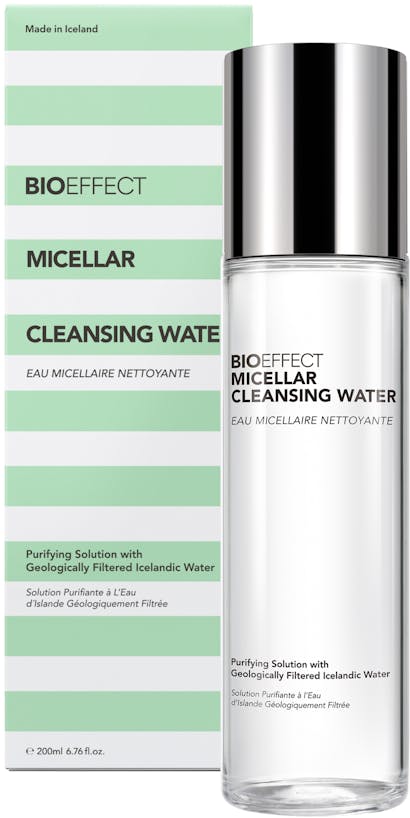A bottle of BIOEFFECT Micellar Cleansing Water sitting upright, in front of its green and white striped packaging.
