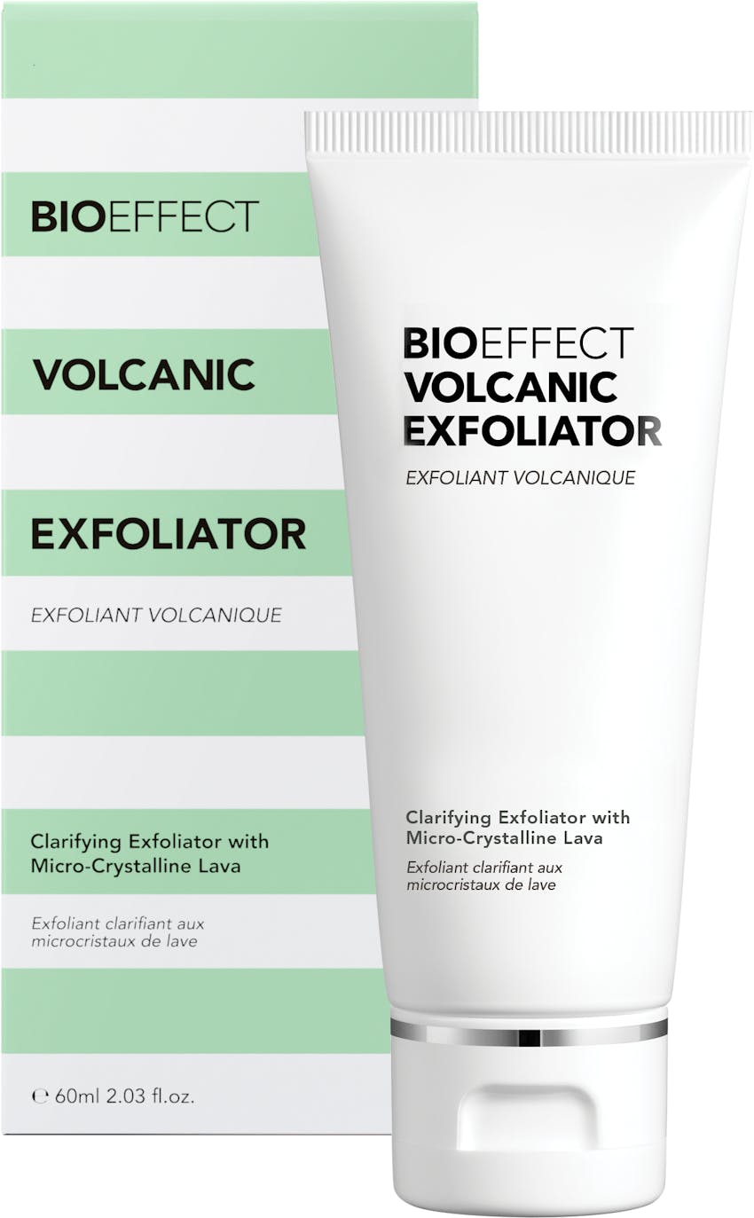 A bottle of BIOEFFECT Volcanic Exfoliator sitting upright, in front of its green and white striped packaging.