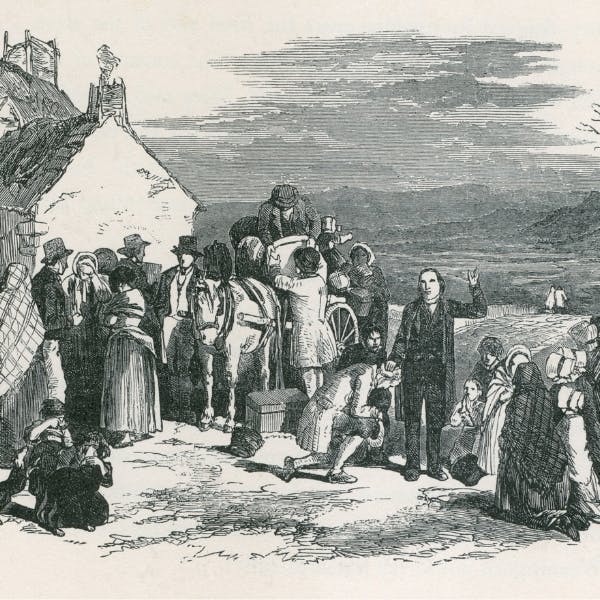 Catholic priest blesses kneeling immigrants leaving Ireland