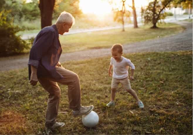 Man playing soccer with grandson with help from hearing care