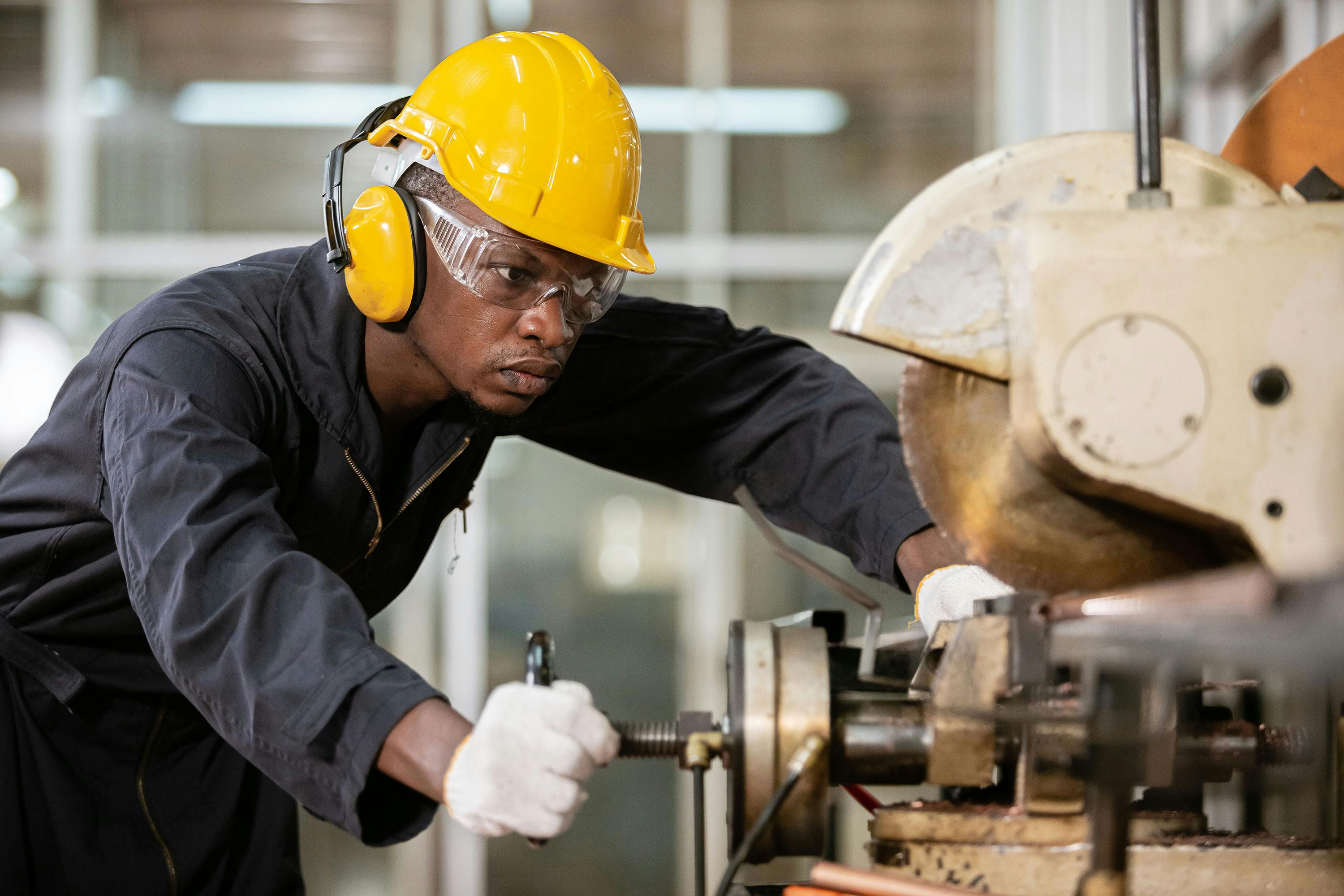 Man woodworking representing how hearing benefits improve workplace safety