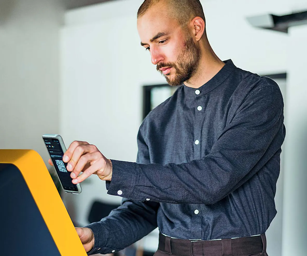 man buying bitcoin from a bitcoin central atm