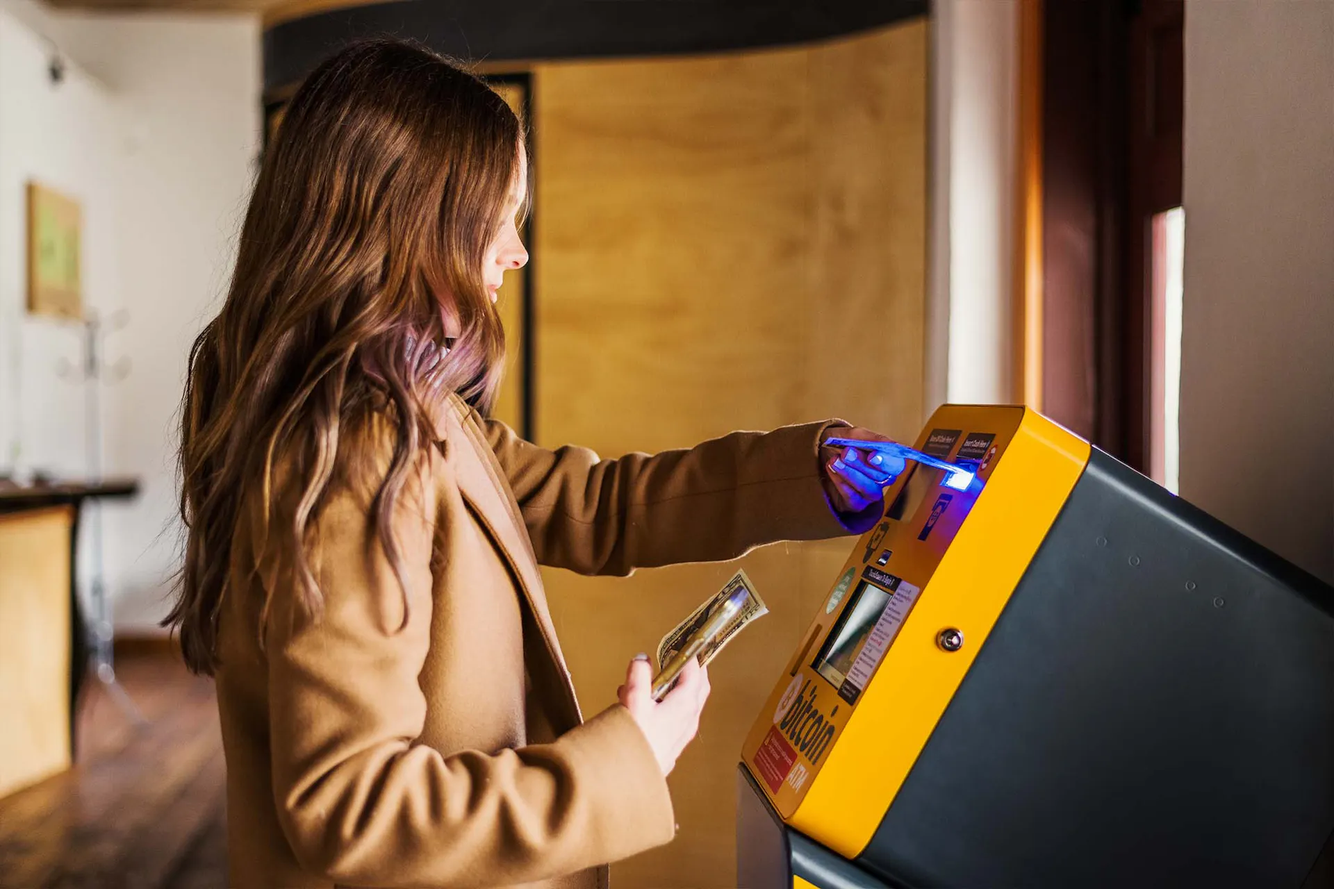 woman scanning phone on bitcoin -central atm machine