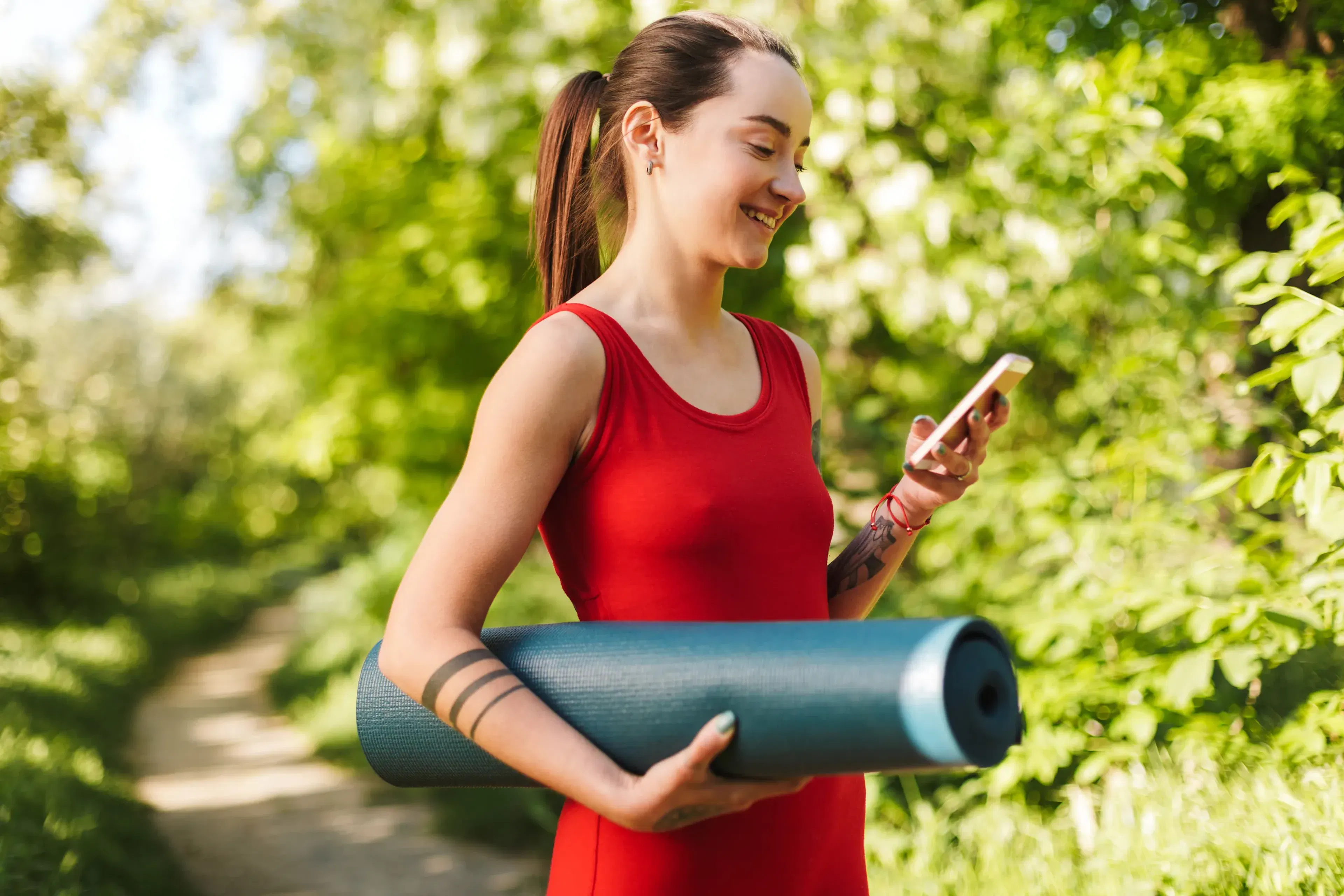 Yogainstruktör med yogamatta kollar appen