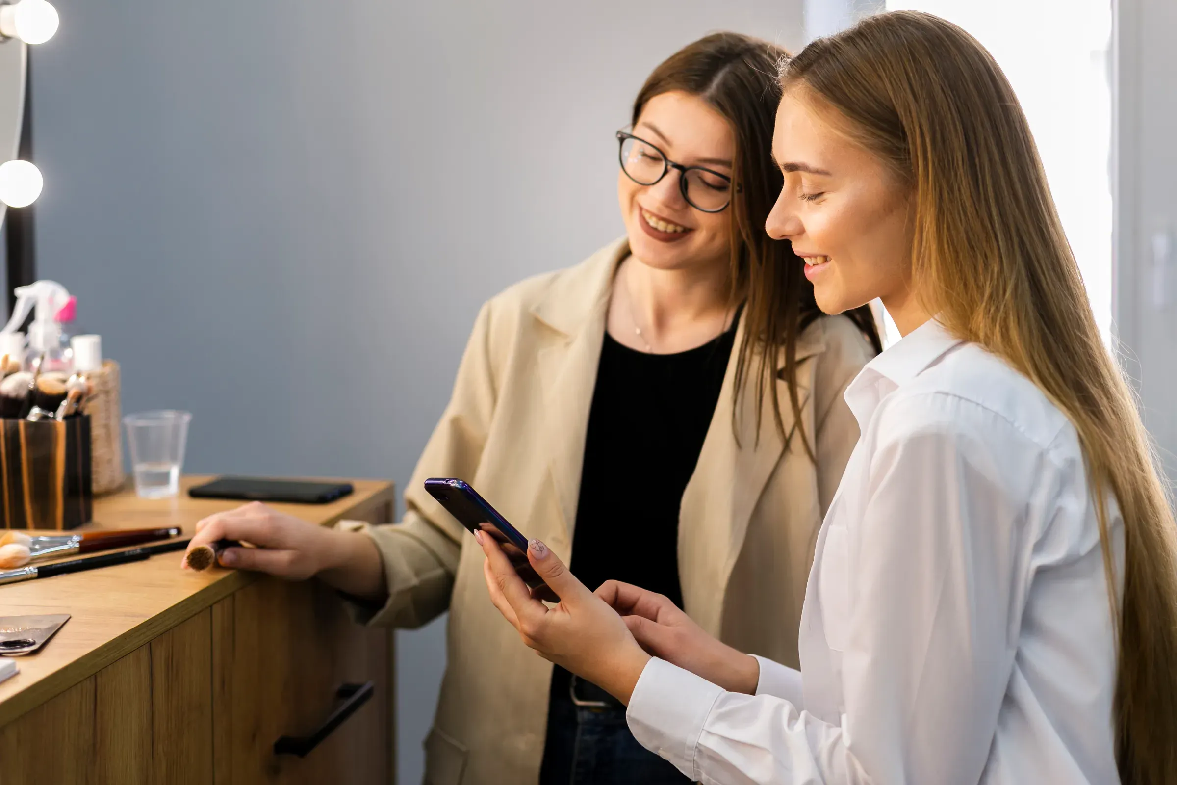 Kund och salongspersonal tittar i mobilen