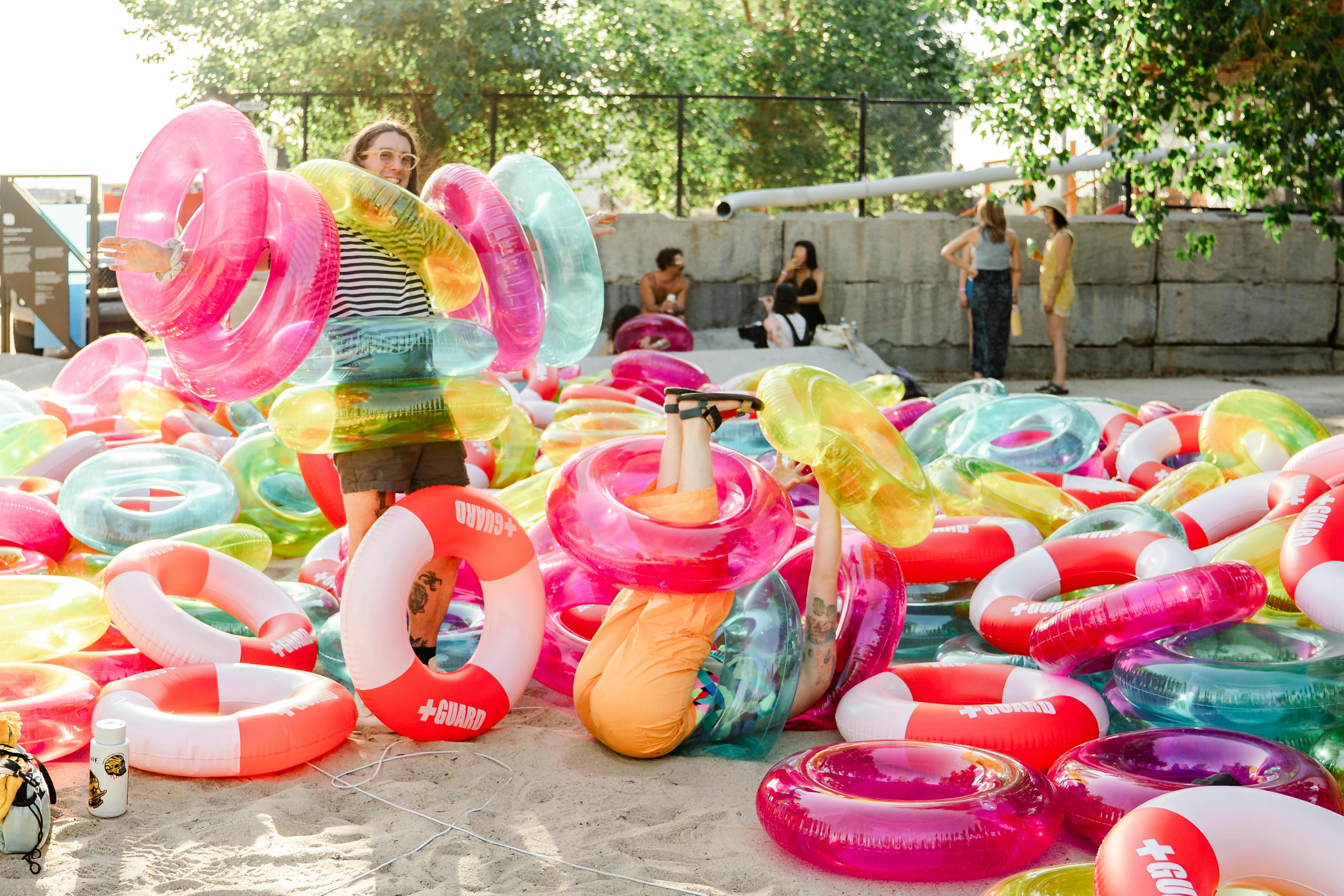 Attendees enjoying Julia Jamrozik and Coryn Kempster, "Lifesavers," 2025, 350 PVC inflatables. Commissioned for "flood" at TAXI Campus in Denver, Colorado. Courtesy of the artist and Black Cube Nomadic Art Museum. Photo by From the Hip Photo. 