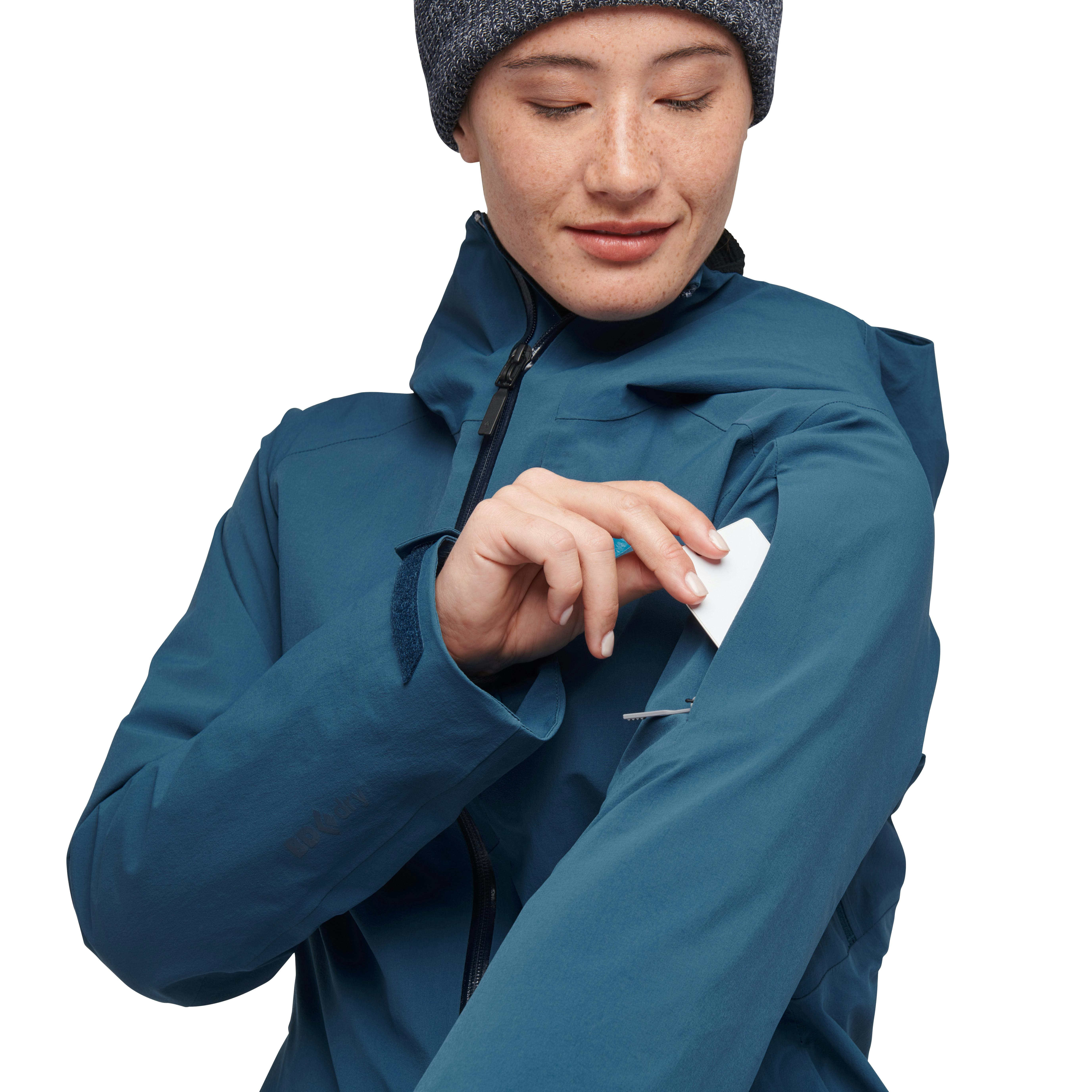 A model pulls a pass out of the right sleeve of her blue Recon Insulated jacket.
