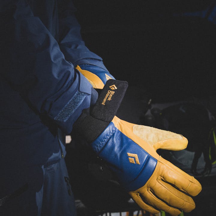 A ski tourer puts on a pair of Black Diamond Spark Mitts in the early morning. 