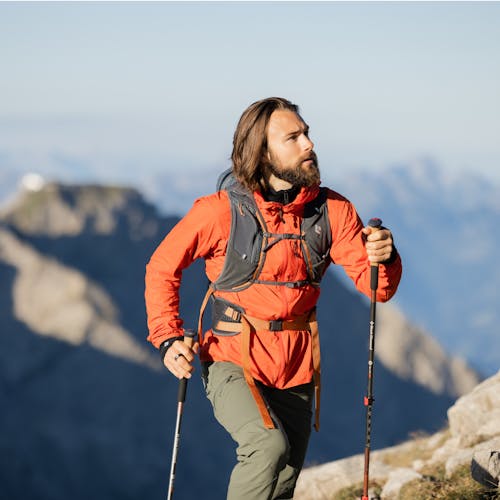 A hiker uses the Pursuit Series Pack and Poles for a hike through the mountains. 