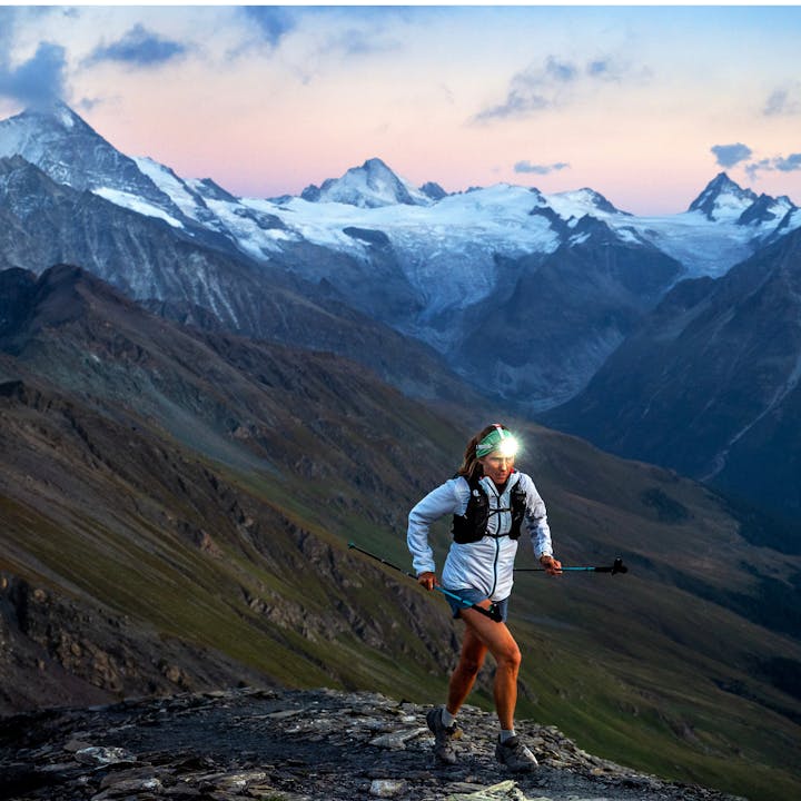 A runner in a Black Diamond Headlamp on a ridge at twilight. 