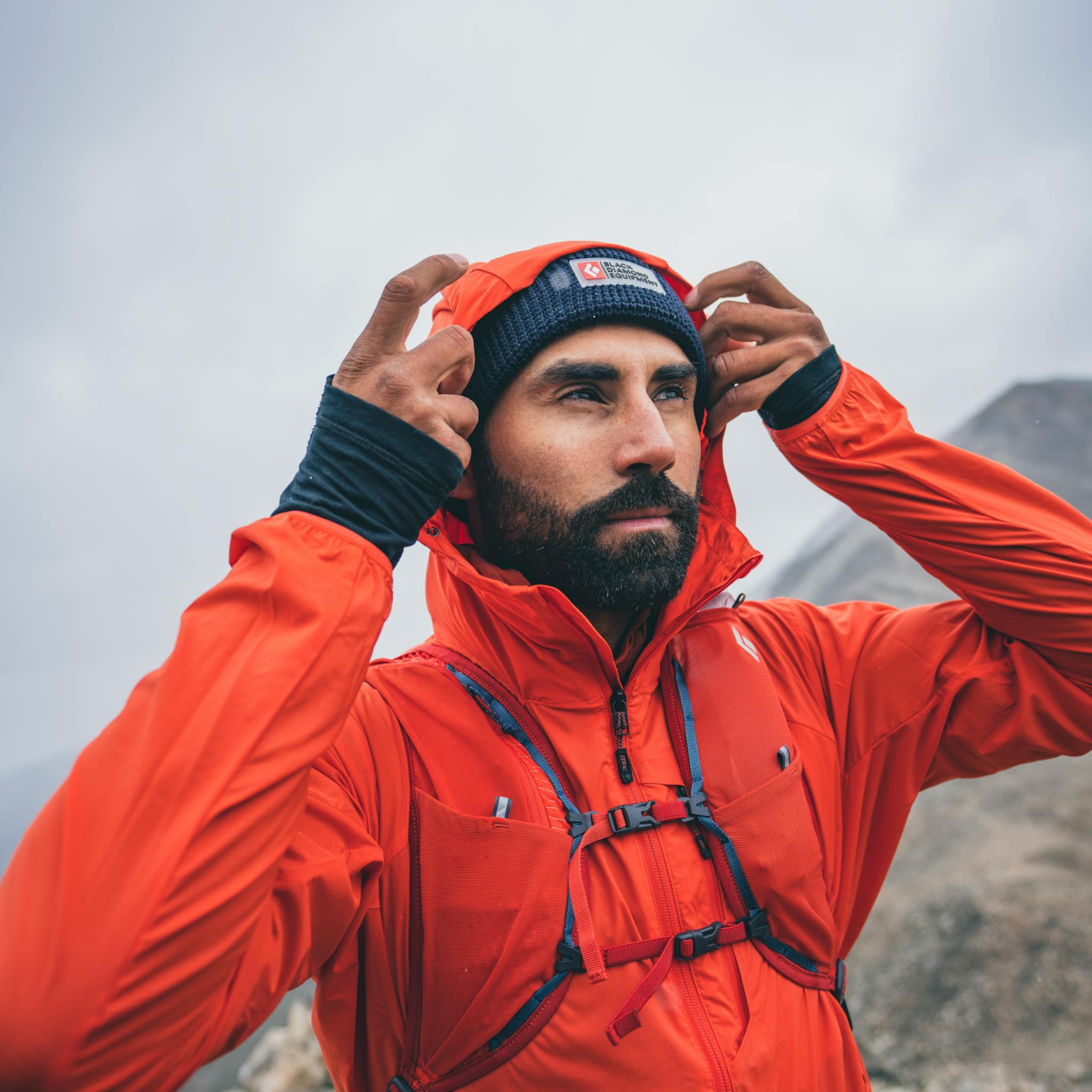 A hiker adjusts the hood of his Alpine Start hoody.
