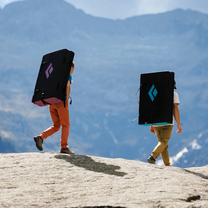 Two climbers carry Black Diamond bouldering crash pads in search of boulders. 
