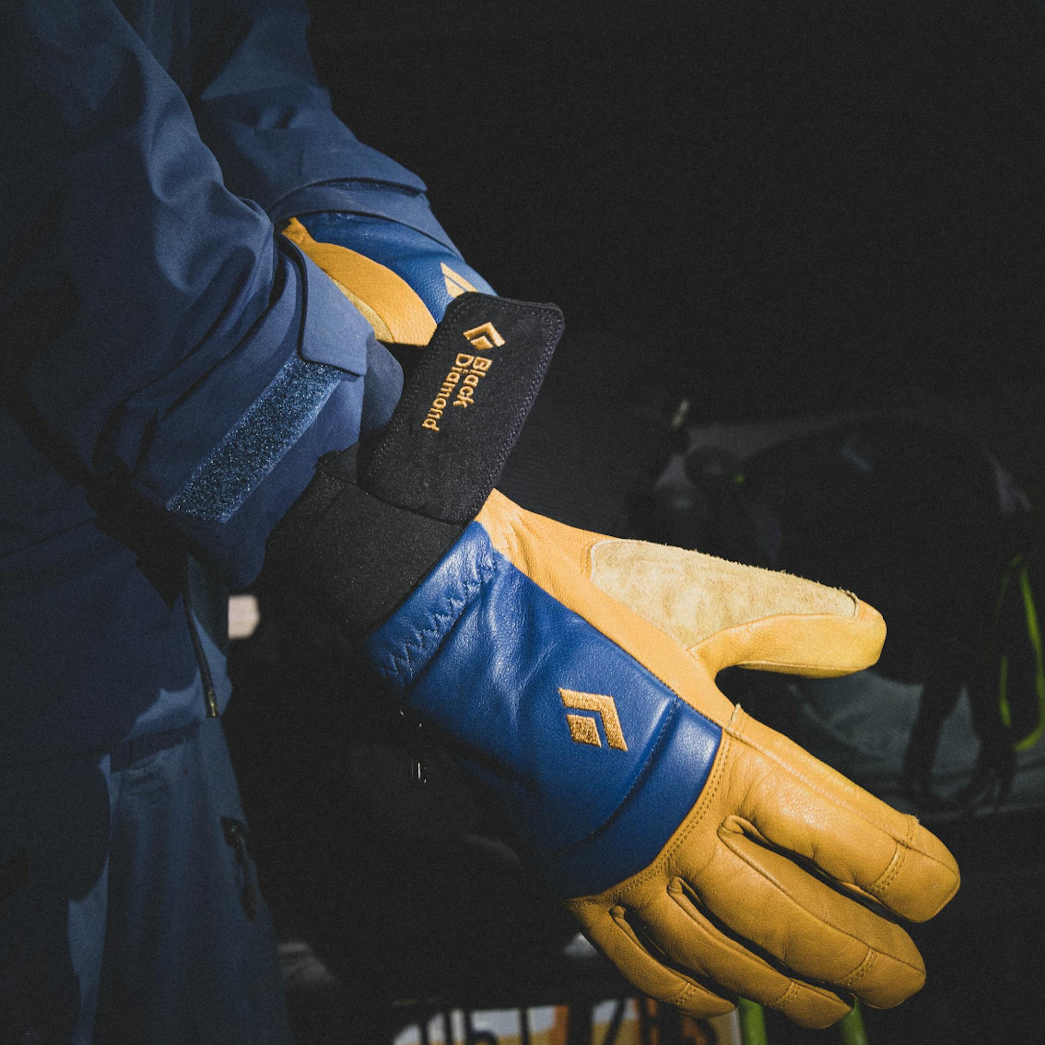 A skier pulls on a pair of Spark Gloves.