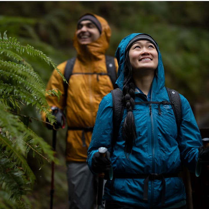 A woman hiking in Olympic National Forest wearing a Black Diamond Rain Jacket. 