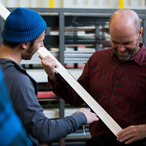two guys inspecting skis
