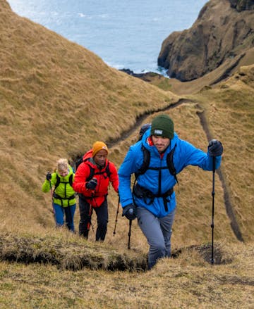 A hiker in Iceland wearing the Black Diamond Stormline stretch rain shell in the kingfisher colorway.