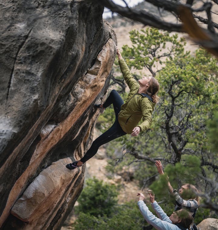 A climber shakes out before topping out on a boulder problem. 