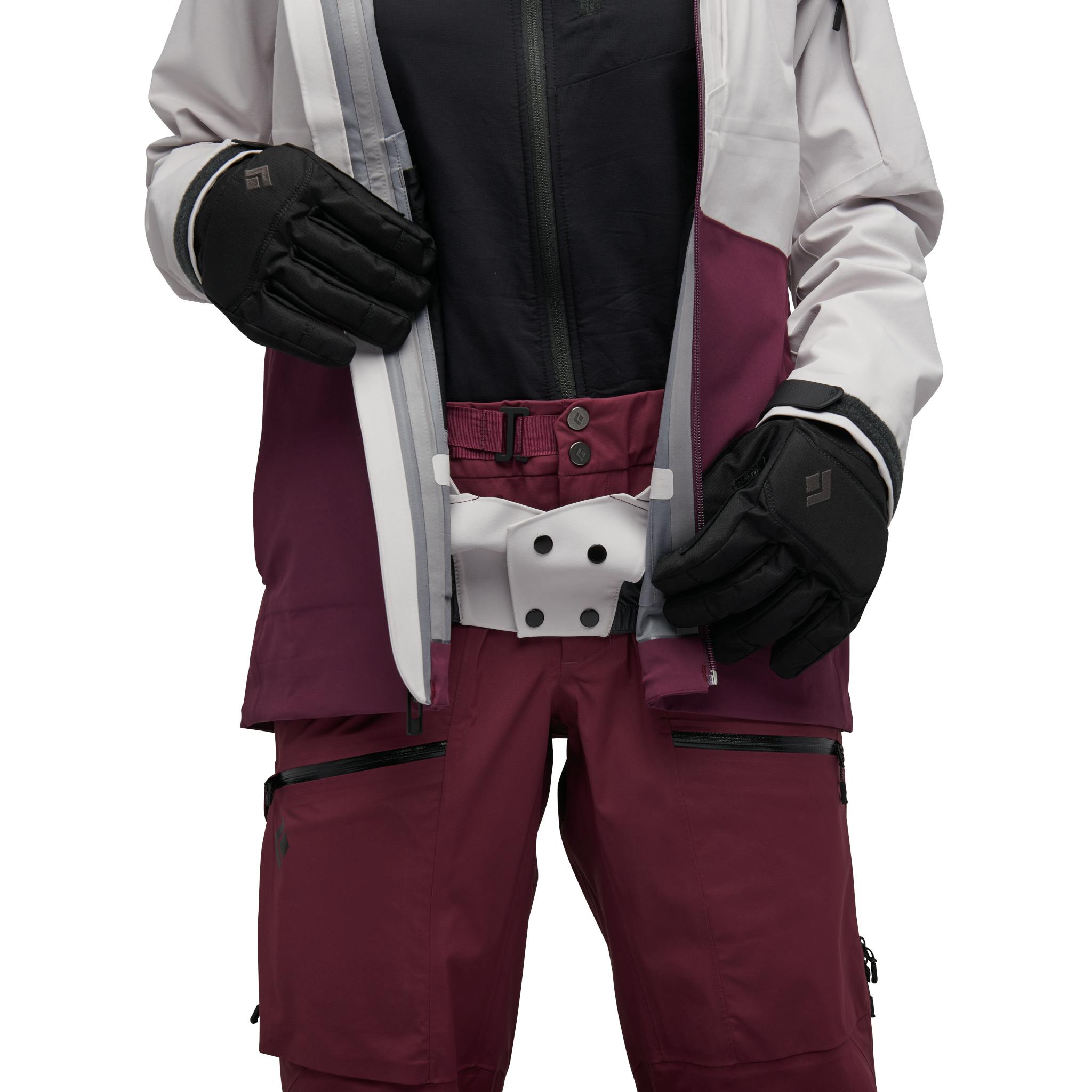 A model adjust the front opening on her pink and maroon Recon Stretch Ski Shell.
