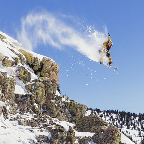 Black Diamond Athlete John Jackson grabbing indy while jumping off a cliff in Crested Butte, CO. 