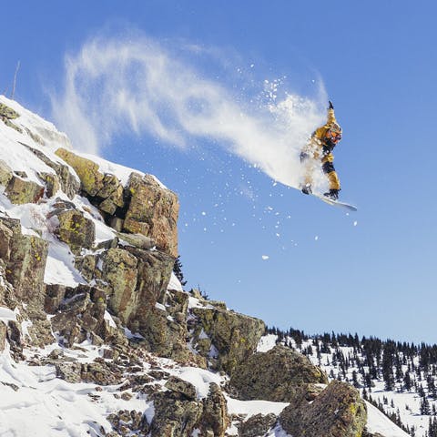 Black Diamond Athlete John Jackson grabbing indy while jumping off a cliff in Crested Butte, CO.