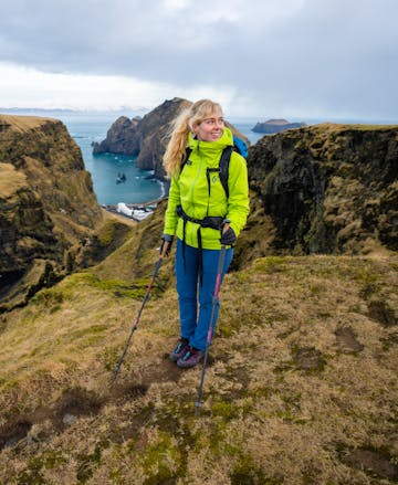 A hiker in Iceland wearing the Black Diamond Stormline stretch rain shell in the Aloe colorway. 