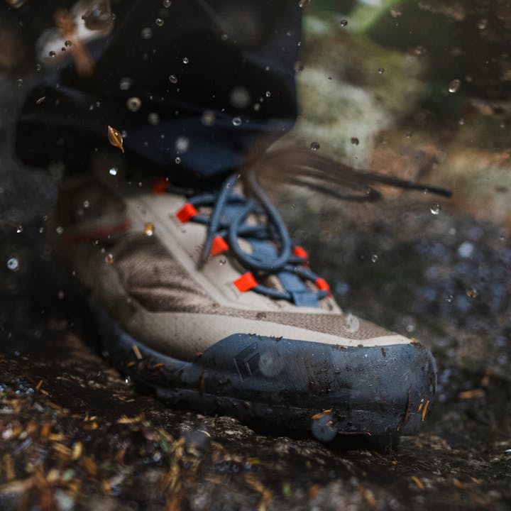 A Mission LT 2.0 Approach shoe kicks up mud and water. 