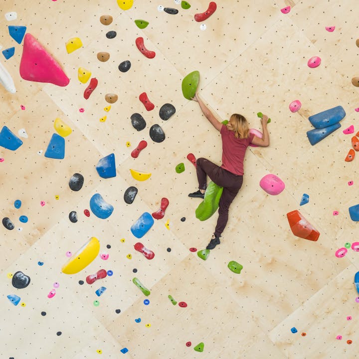 woman climbing in the gym | indoor rock climbing gear | climbing packs