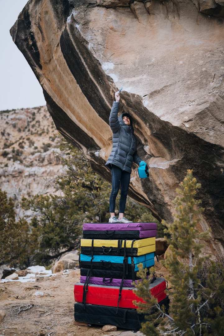 Natalia Grossman standing on top of a stack of crash pads