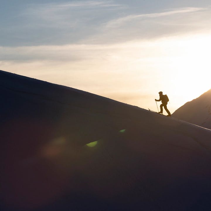 Photograph by Jeff Cricco of man skinning up a mountain at sunrise