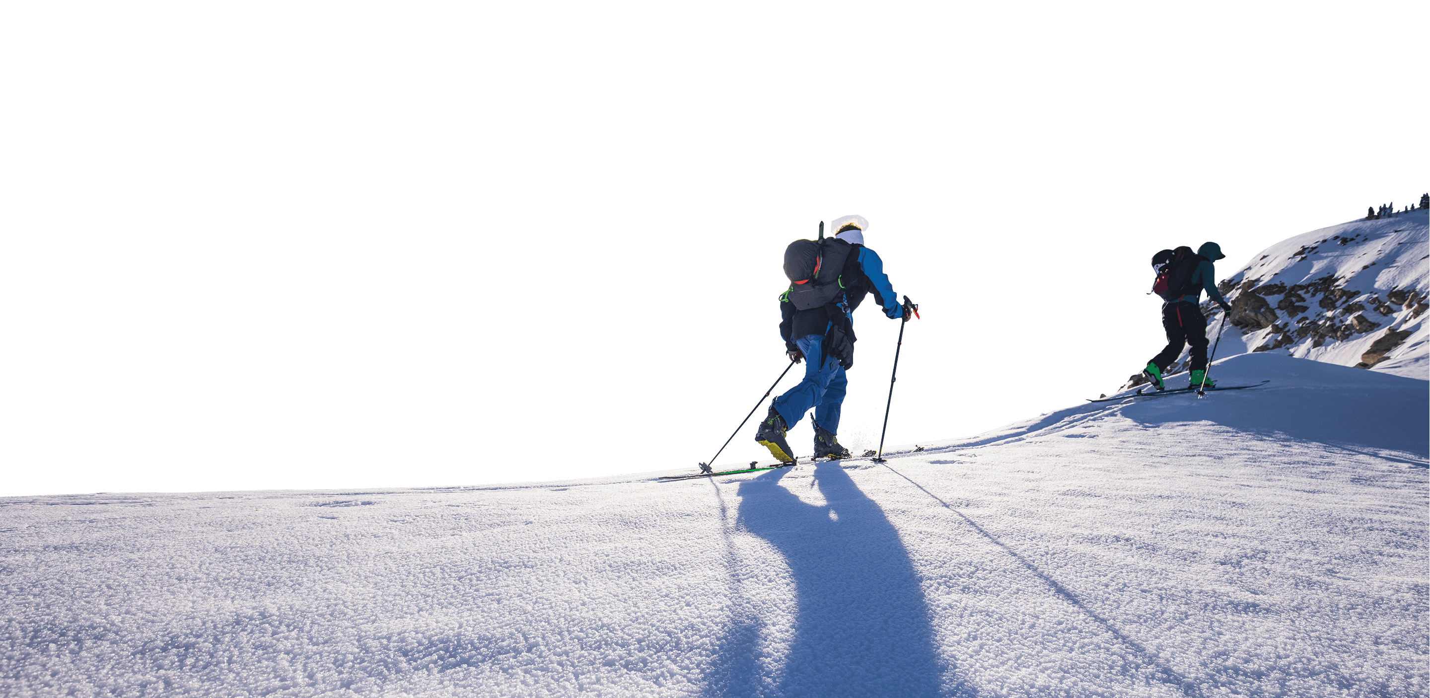 Two skiers skinning up a ridge in the backcountry using Black Diamond equipment.