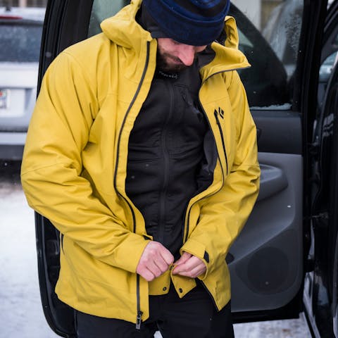 A skier zips up their shell Jacket wearing the Black Diamond Coefficient Hoody as a base/mid layer.