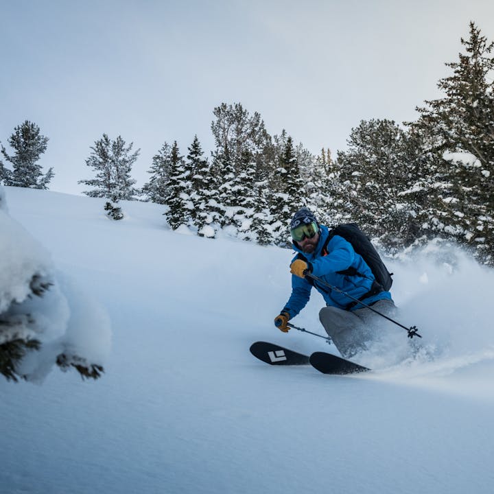 A skier slashes power in the early morning. 