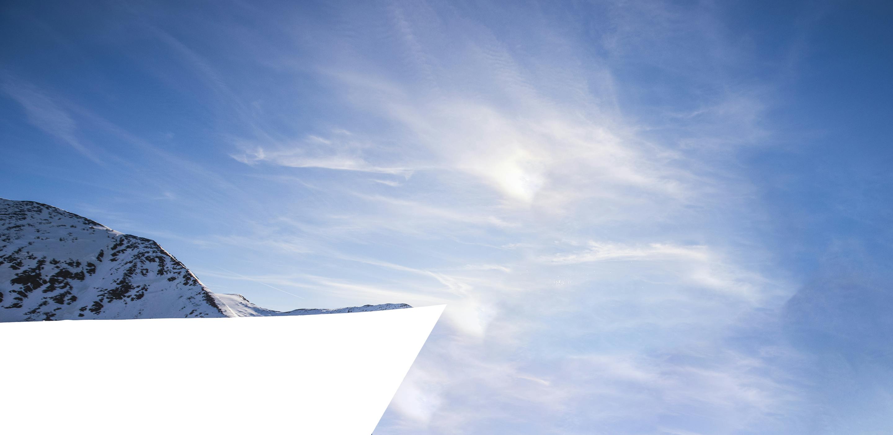 Parallax background for two skiers skinning up a ridge in the backcountry using Black Diamond equipment.