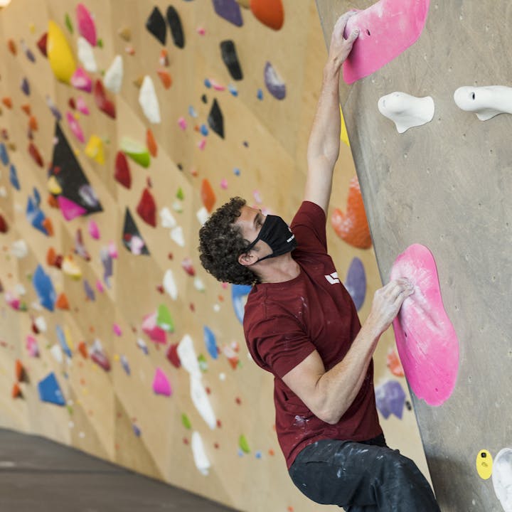 Photograph by Christian Adam of man bouldering in a gym.