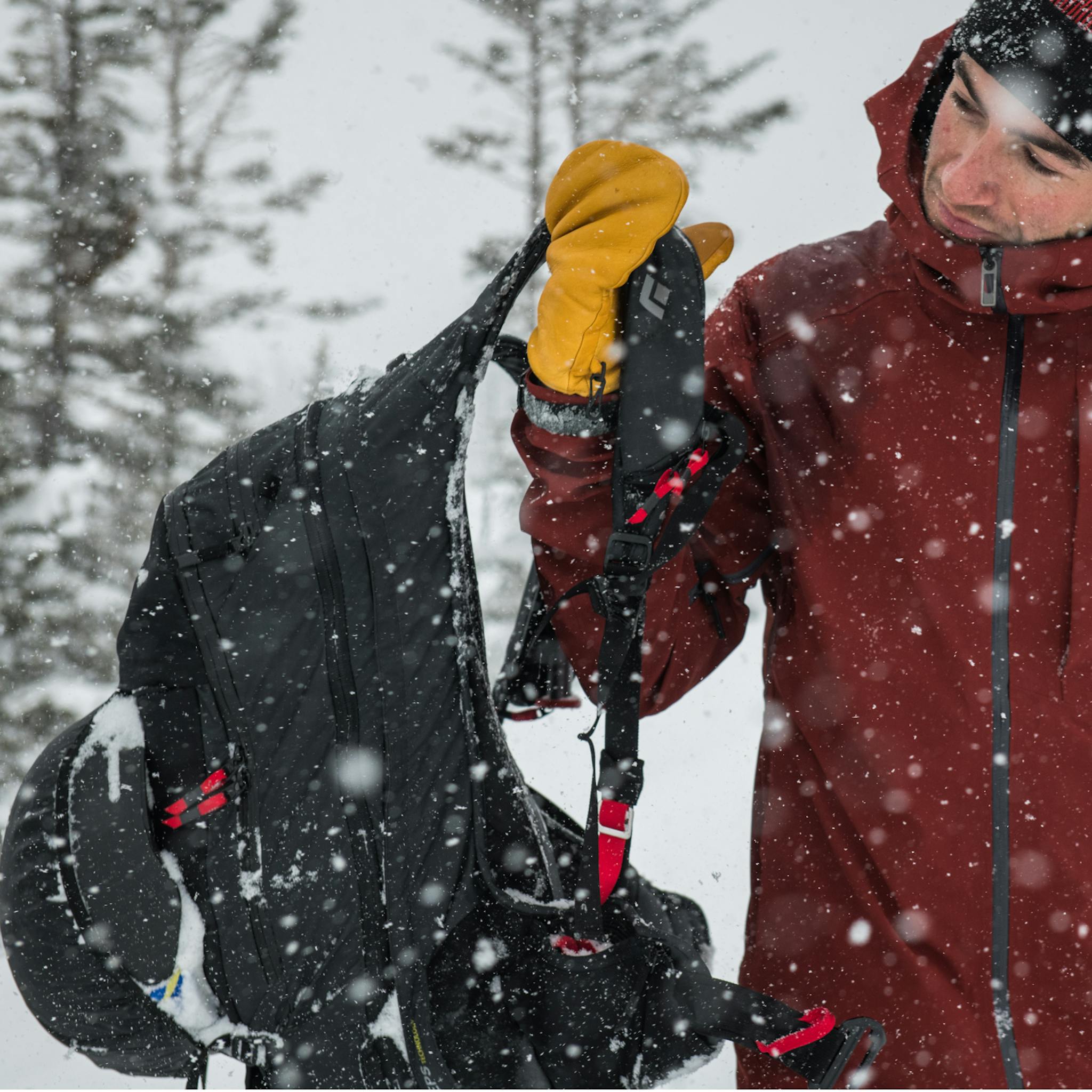 In the snow, a skier puts on his Jetforce Pack