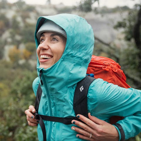 Emilie Hernandez hiking in the rain to the crag.