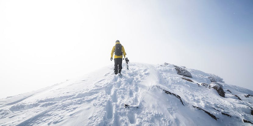 Snowboarder on ridge carrying board