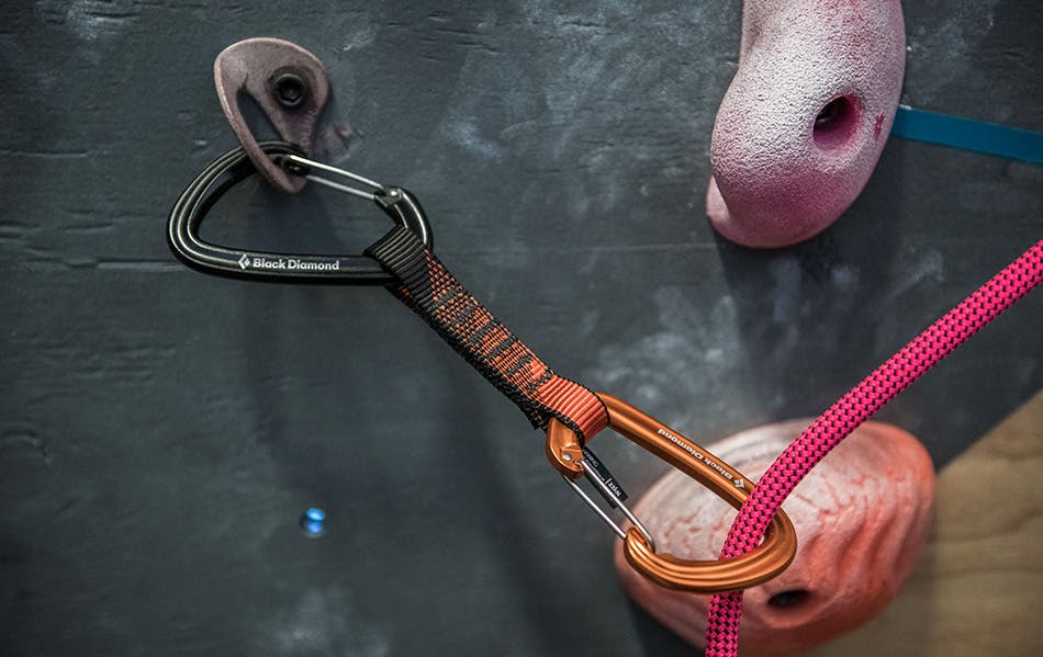 Rope clipped in quickdraw in climbing gym.