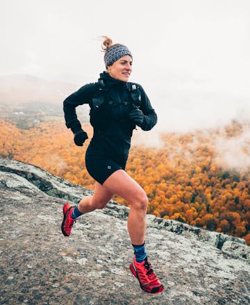 A runner wears the Black Diamond Women's Coefficient LT Hybrid Hoody on a frigid morning run.
