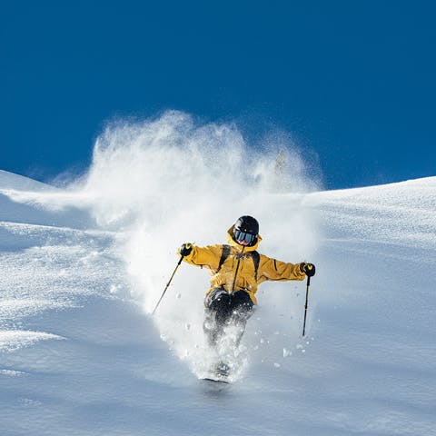 Black Diamond Athlete Parkin Costain straight lining a powder field.