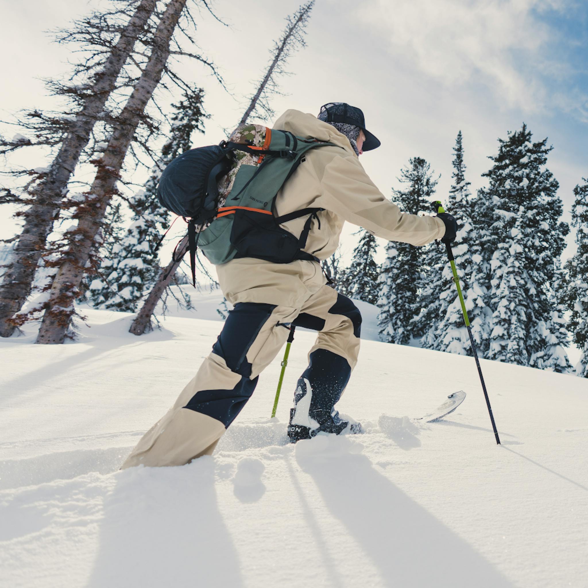 Splitboarder in the backcountry walking uphill in Khaki Recon Pro Outfit
