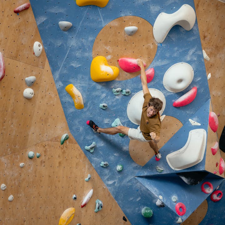 A climber celebrates the after finishing a boulder in a gym. 